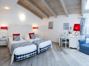 a bedroom with two beds and a desk and a chair at La Ciliegina Lifestyle Hotel in Naples