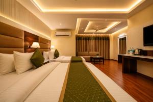a hotel room with a large bed and a television at Hotel Geet Deluxe Near Connaught Place and New Delhi Railway Station in New Delhi +40 photos