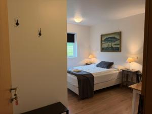 ein Schlafzimmer mit einem Bett und zwei Tischen mit Lampen in der Unterkunft Stöð-INN in Stöðvarfjörður