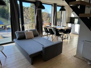 a living room with a couch and a table with chairs at Harrachovský Chalet Gryf u sjezdovky in Ryžoviště +34 photos