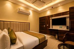 a hotel room with a bed and a television at Hotel Geet Deluxe Near Connaught Place and New Delhi Railway Station in New Delhi
