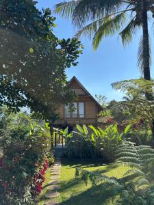 a house in the middle of a garden at Dewi Rinjani Homestay in Tetebatu