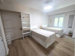 a small bedroom with two beds and a window at Martita Home in Zaragoza