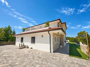a white house with a brick driveway at Villa Dijana with Pool - Sol Tours in Kras
