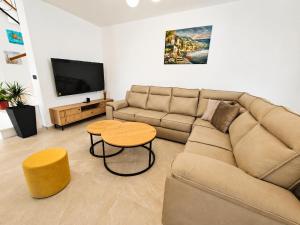 a living room with a couch and a table and a tv at Villa Dijana with Pool - Sol Tours in Kras