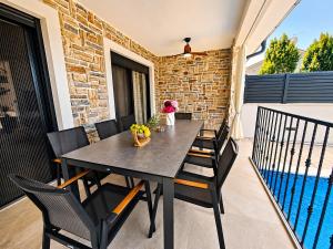a table and chairs on a balcony with a pool at Villa Dijana with Pool - Sol Tours in Kras