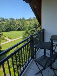 a balcony with two chairs and a view of a field at Ferienwohnung Weiding in Rutzenmoos