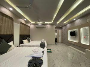 a hotel room with two beds and a tv at Parth King Resort Tarapith A Unit of Prattay Infratech Private Limited in Tarapith