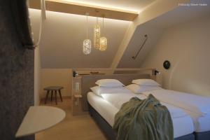 a bedroom with a large bed with white sheets and pillows at Hotel Nationalpark in Illmitz +62 photos
