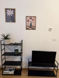 a living room with a black book shelf and a television at Cozy Central Apartament II in Bacău +2 photos