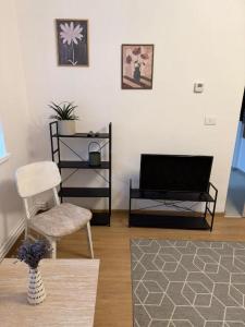 a living room with a tv and a chair at Cozy Central Apartament II in Bacău