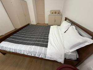 a bedroom with a bed with a black and white comforter at Cozy Central Apartament II in Bacău