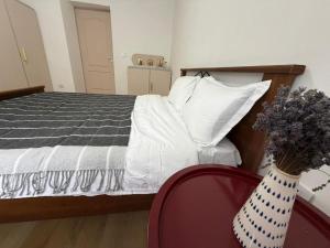 a bedroom with a bed and a vase with flowers at Cozy Central Apartament II in Bacău