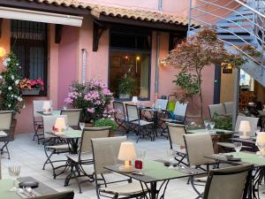 an outdoor patio with tables and chairs and flowers at Hostellerie du Forez in Saint-Galmier