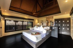 a bedroom with a large bed with white sheets and pillows at Cauayan Boutique Private Island - formerly Cauayan Island Resort in El Nido