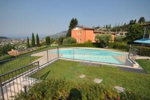 a swimming pool in a yard next to a house at ApartmentsGarda - Baia D'Argento Residence in Costermano