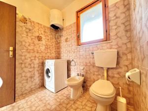 a bathroom with a toilet and a washing machine at Villetta Mascagni in Lido Adriano +25 photos