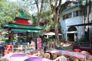 a group of tables and chairs in front of a building at Horseland Hotel & Mountain Spa in Matheran