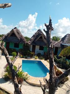 a resort with a swimming pool in front of a building at Sweet Home in Kiwengwa