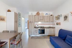 a living room with a blue couch and a kitchen at Casa Serena in San Teodoro