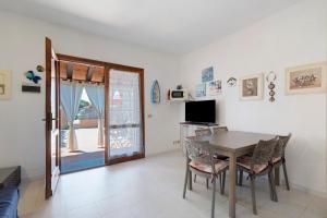a dining room with a table and a television at Casa Serena in San Teodoro