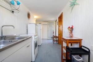 a kitchen with a sink and a refrigerator at Villa Ondina 1 Carloforte in Carloforte