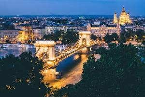 a view of a bridge over a river at night at Roombach Hotel Budapest Center in Budapest