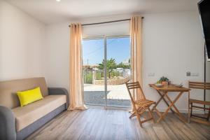 a living room with a couch and a sliding glass door at Vilas Salero in Moncarapacho