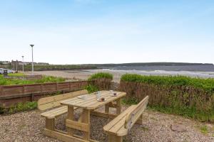 a wooden picnic table sitting next to a beach at 2 Bed in Thurso oc-n41742 in Thurso
