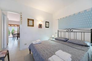 a bedroom with a large bed with two towels at Casa Serena in San Teodoro