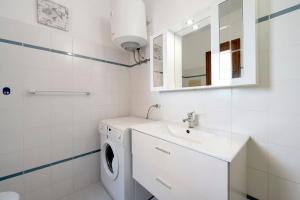 a white bathroom with a washing machine and a sink at Casa Serena in San Teodoro +12 photos