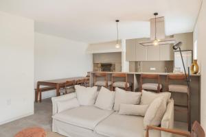 a living room with a white couch and a kitchen at Casa Pitoresca - Refugio Esposende in Braga