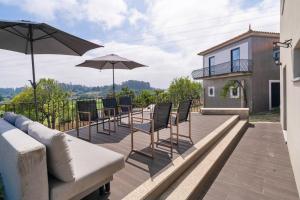 a patio with chairs and umbrellas on a house at Casa Pitoresca - Refugio Esposende in Braga