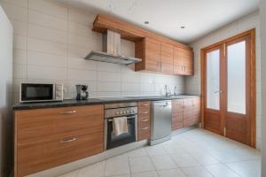 a kitchen with wooden cabinets and a stove top oven at Casa Nord in El Port de la Selva