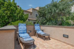 two blue and white chairs sitting on a balcony at Casa Nord in El Port de la Selva