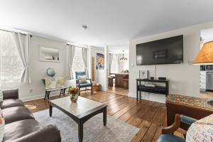 a living room with a couch and a table at Historic Waterfront Home and Cottage in Groton