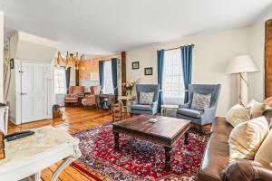 a living room with a couch and a table at Historic Waterfront Home and Cottage in Groton