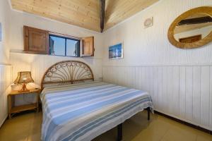 a small bedroom with a bed and a mirror at Villa Ondina 1 Carloforte in Carloforte