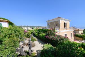 a view of a garden with flowers and a building at Villa Ondina 1 Carloforte in Carloforte