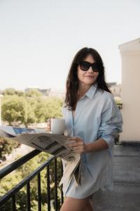 a woman in a dress holding a newspaper at 1.75 Paris La Trêve in Paris