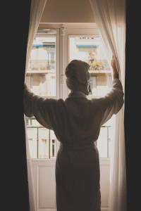 a person is looking out of a window at 1.75 Paris La Trêve in Paris +29 photos