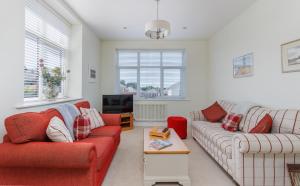 a living room with two couches and a tv at 5 Old School Mews Shanklin in Shanklin