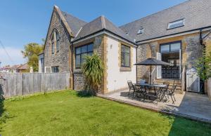 a house with a table and chairs in a yard at 5 Old School Mews Shanklin in Shanklin