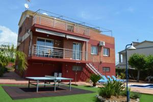 a red brick building with a picnic table in front of it at VILLA LAGEM, Casa con piscina, barbacoa, jardín in Cubelles
