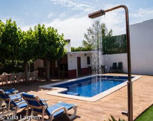 a swimming pool with a water fountain at VILLA LAGEM, Casa con piscina, barbacoa, jardín in Cubelles