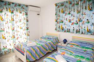 two twin beds in a room with curtains at VILLA LAGEM, Casa con piscina, barbacoa, jardín in Cubelles +39 photos