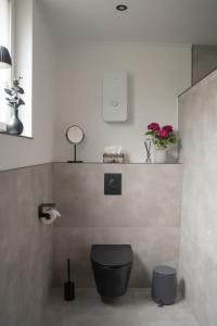 a bathroom with a toilet and flowers on a wall at Ferienwohnung Eifelmomente in Rittersdorf