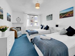 a white bedroom with two beds and a fireplace at Keld Apartment Porlock in Porlock