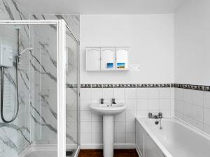 a white bathroom with a sink and a shower at Keld Apartment Porlock in Porlock +22 photos