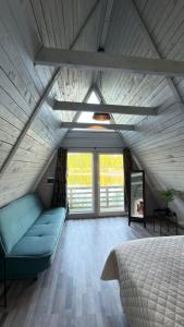 a bedroom with a bed and a couch and windows at Tūjas dīķi in Tūja +64 photos